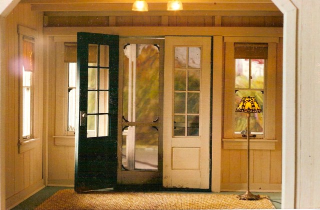 Main room with white-pickled walls, painted floor and grass mat.