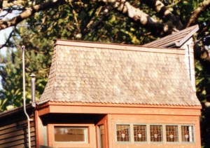 scalloped, or fishscale shingle roof, capping the stained-glass windows.