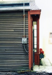Alley side of the building with shiplap siding and water meter